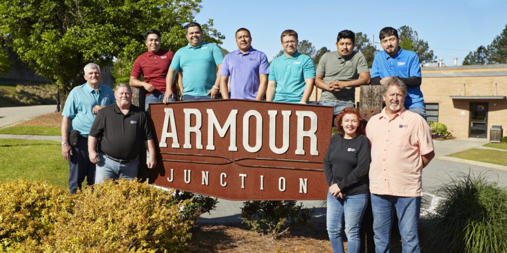 Commercial property management team standing by sign that reads "Armour Junction"